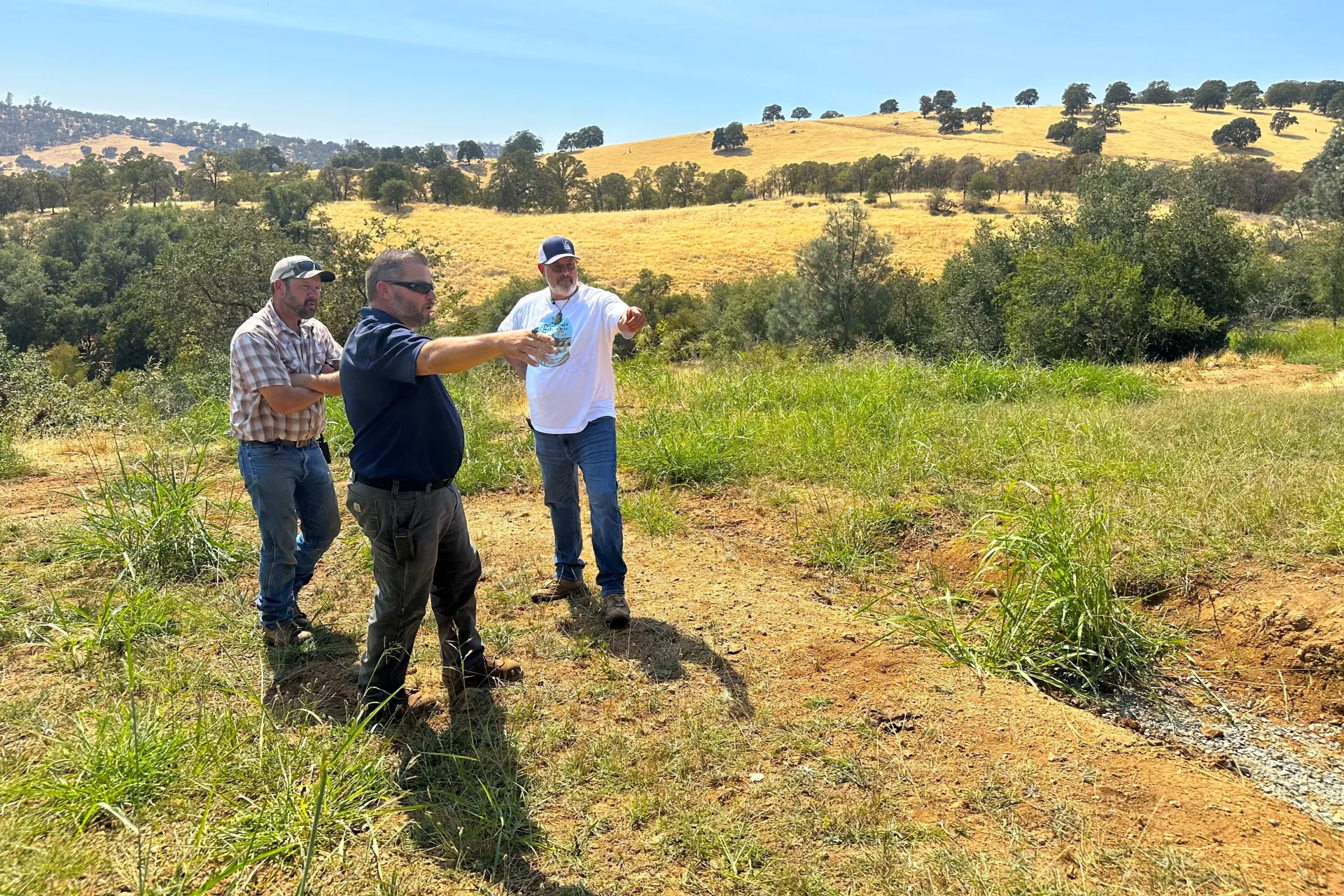 Nikolai Schweitzer gestures at the trench built into a hillside at Sierra Foothill REC