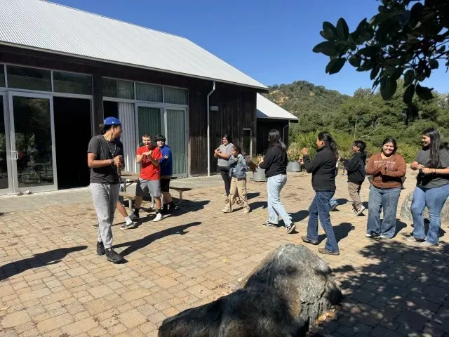 Jóvenes de la tribu participan en un juego de mano tradicional.