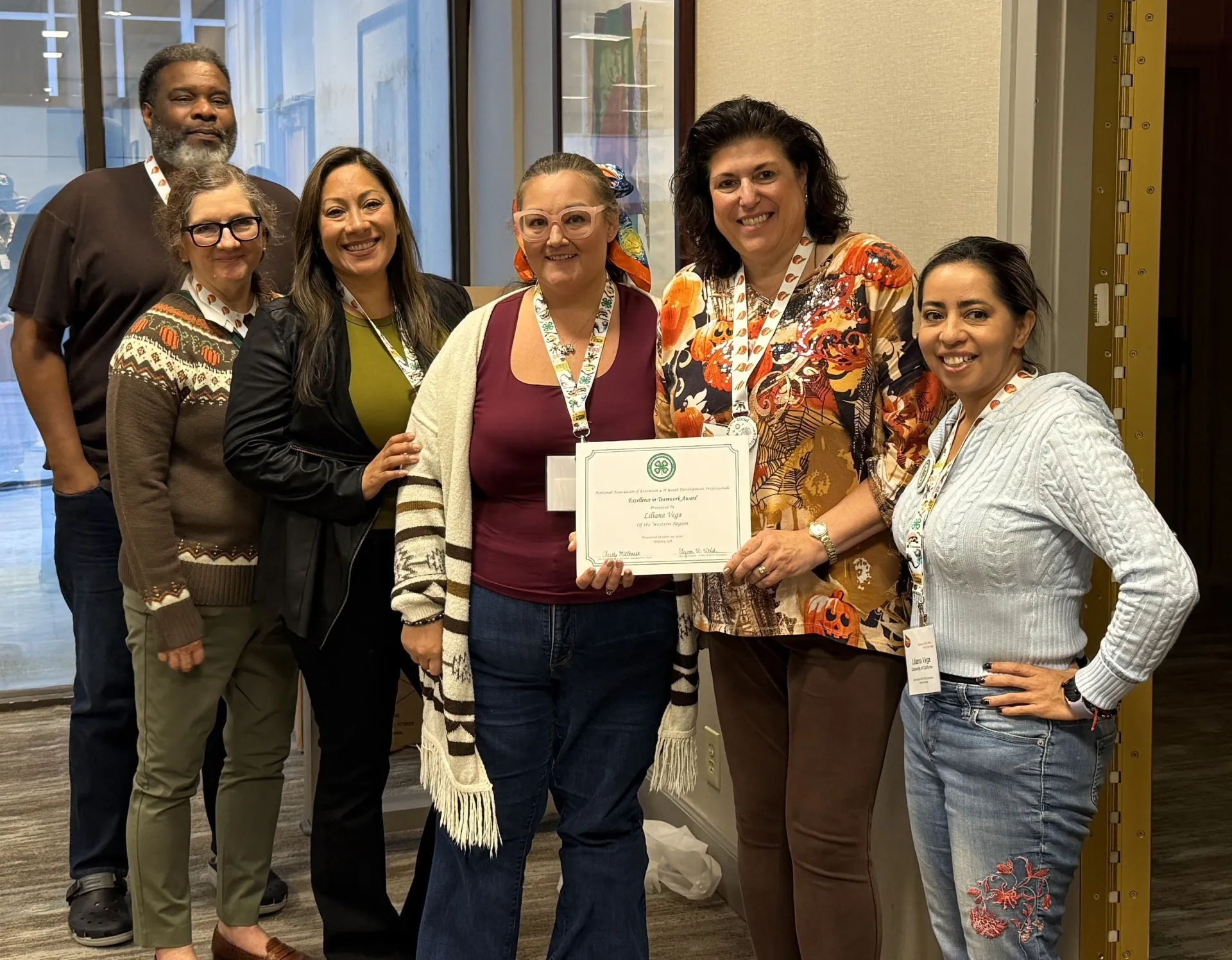 6 people pose with a certificate held by one person