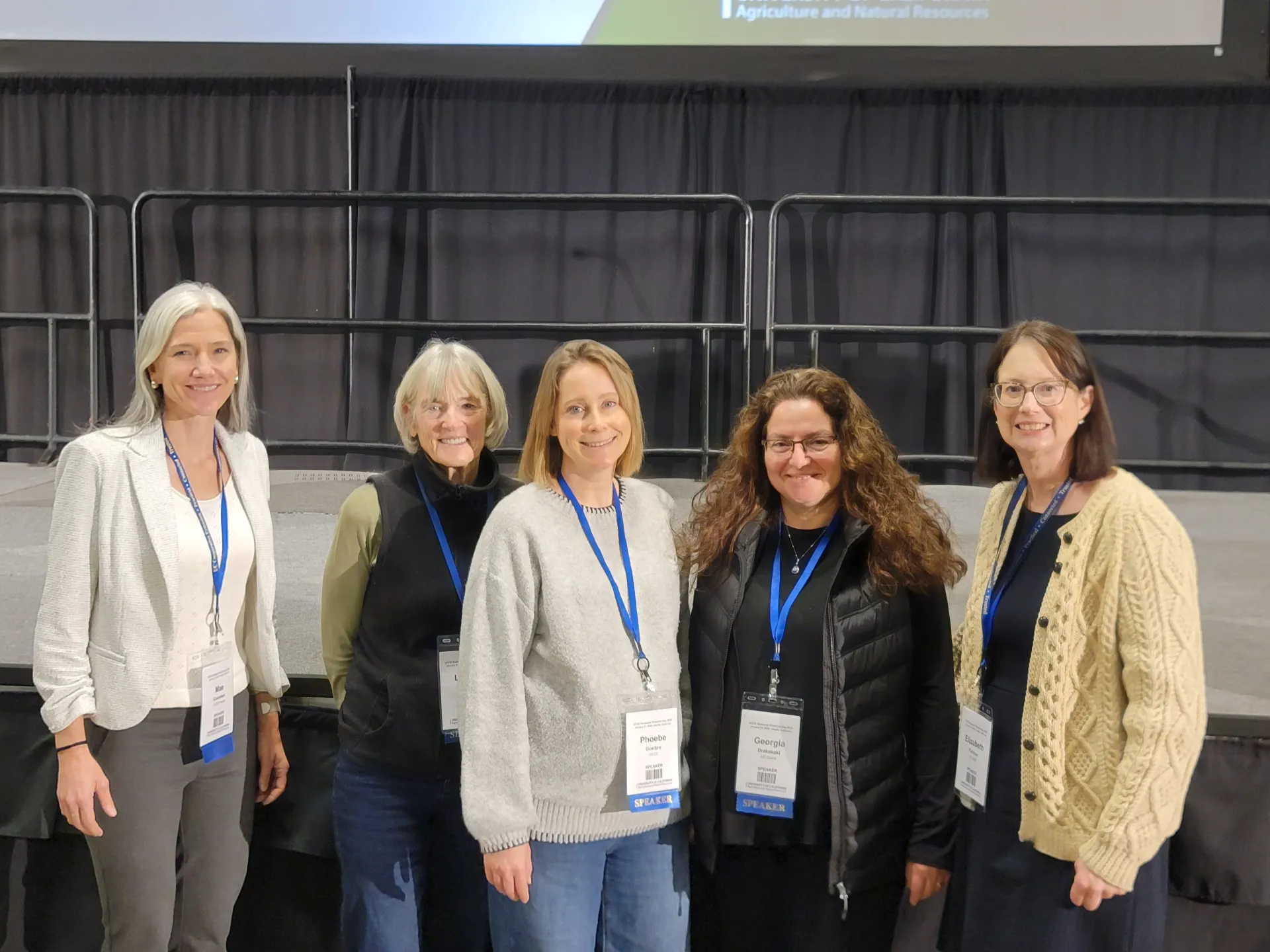Five women scientists stand in a row