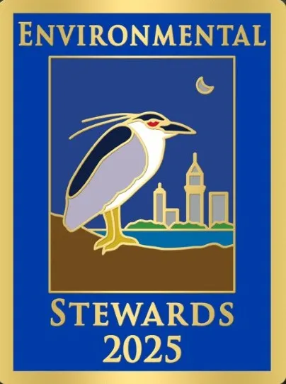 A pin that has an image of a black-crowned night heron with the city of oakland in the background that says environmental Stewards 2025