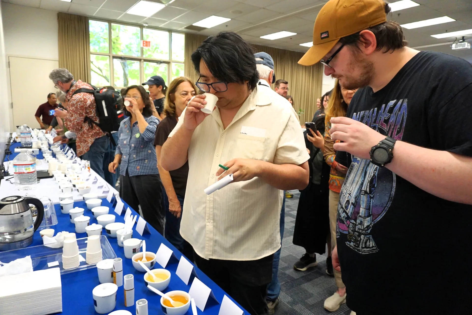 Two Kearney REC Tea Day attendees put their noses into cups to evaluate the aroma of various teas