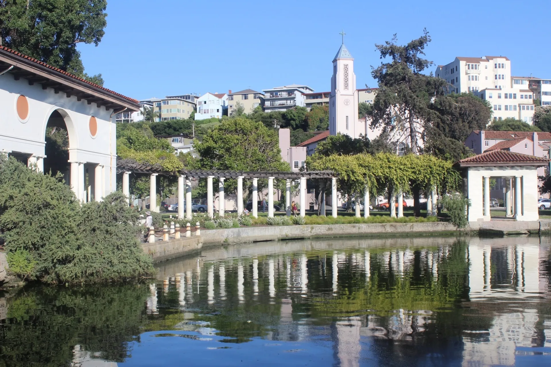 curved side of an Oakland urban reservoir with trees and vegetation 