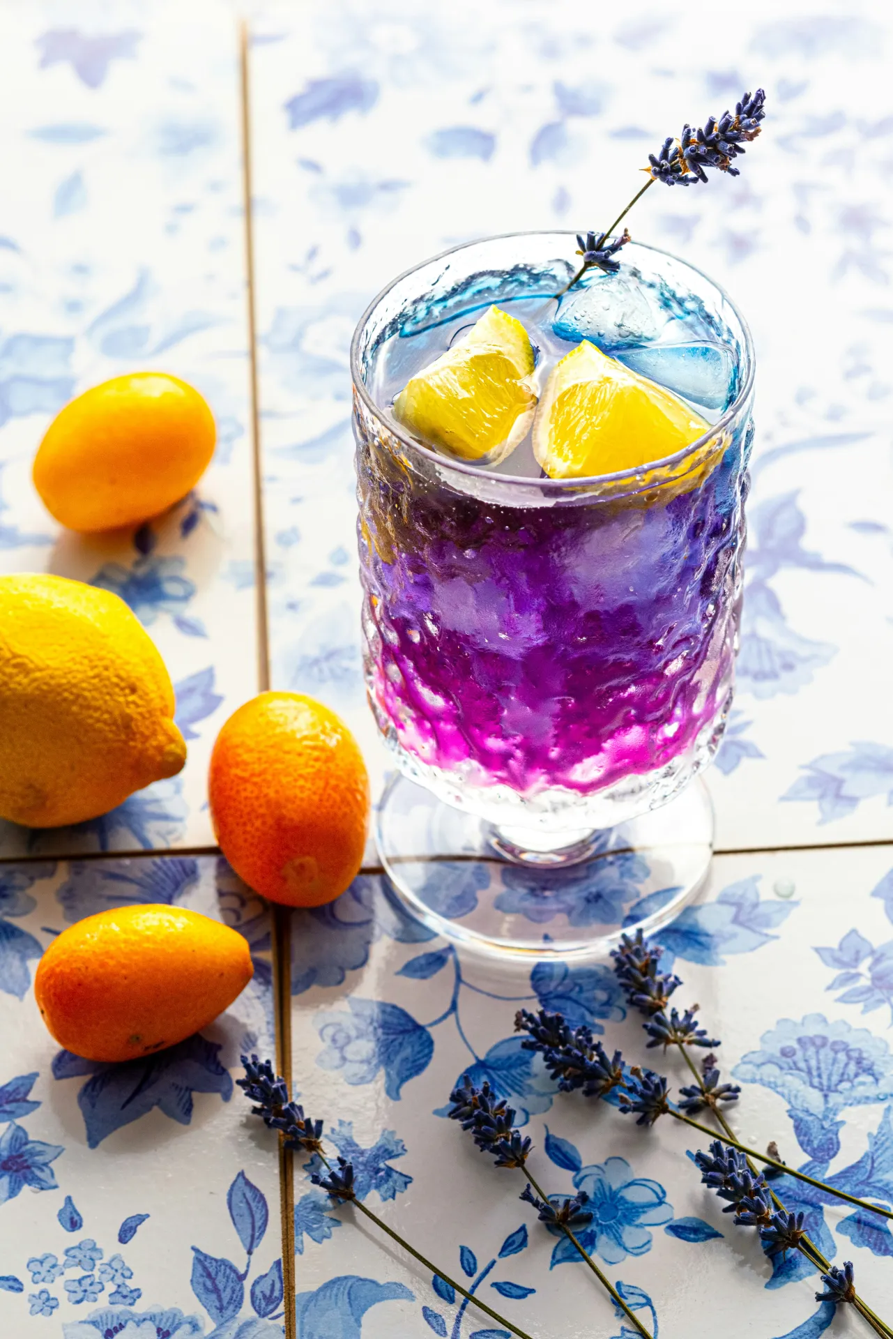 Cocktail with a slice of lemon and sprig of lavender. 
