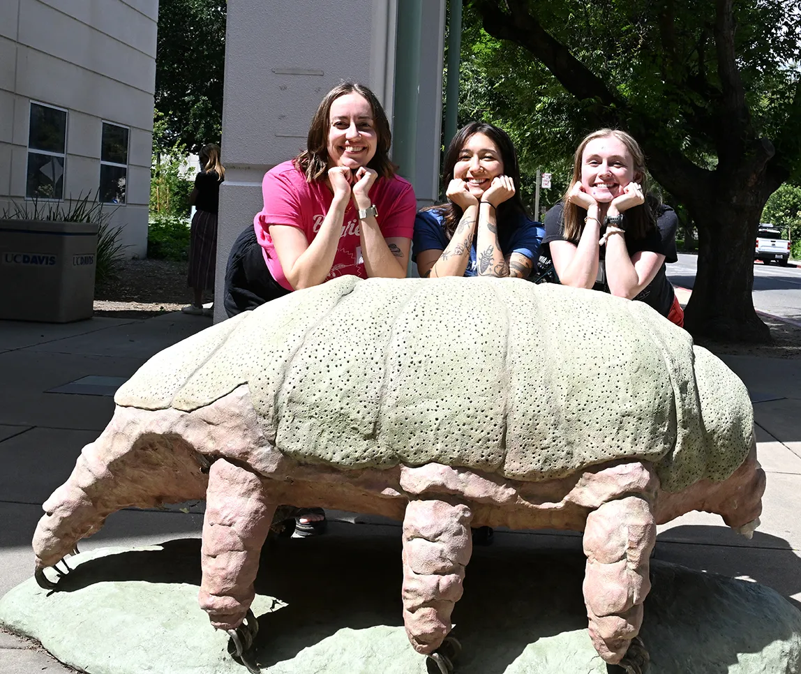 EGSA members (from left) Marielle Hansen Friedman, Mia Lippey and Grace Horne pose by the tardigrade sculpture in front of the Bohart Museum of Entomology.