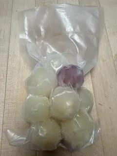 A freezer bag full of small, frozen onions.