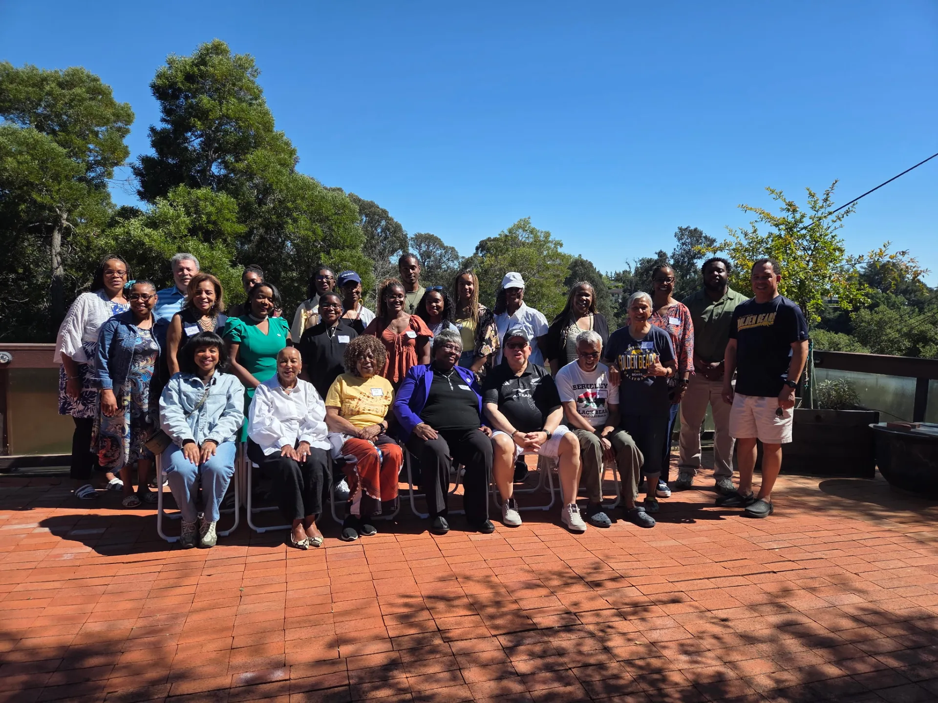 Standing and sitting in chairs on a back patio are 25 Black adults and college students