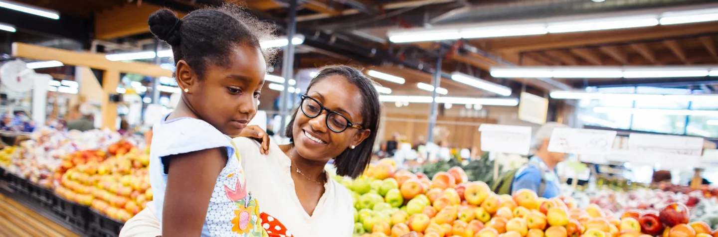 image of woman and child in grocery store produce section