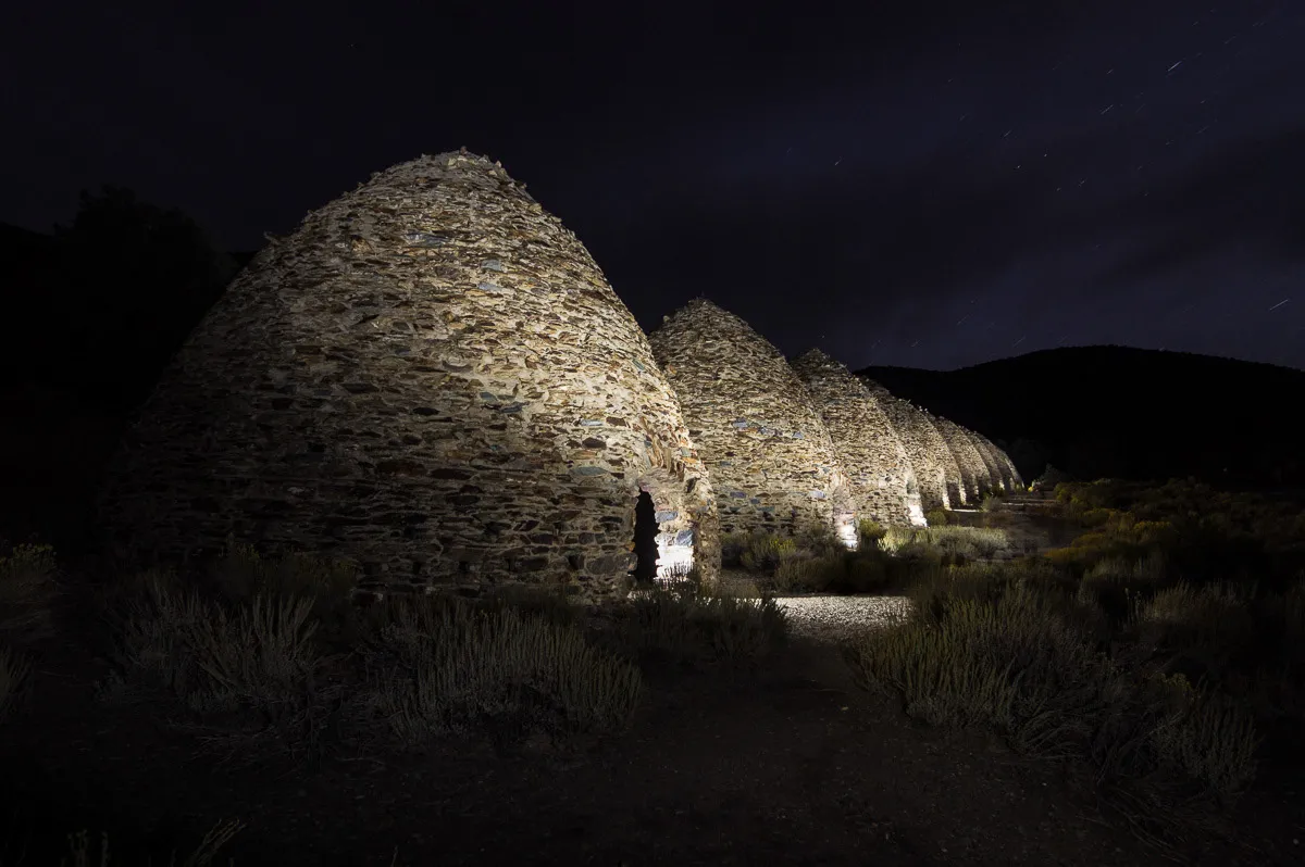 Charcoal kilns lit up at night.