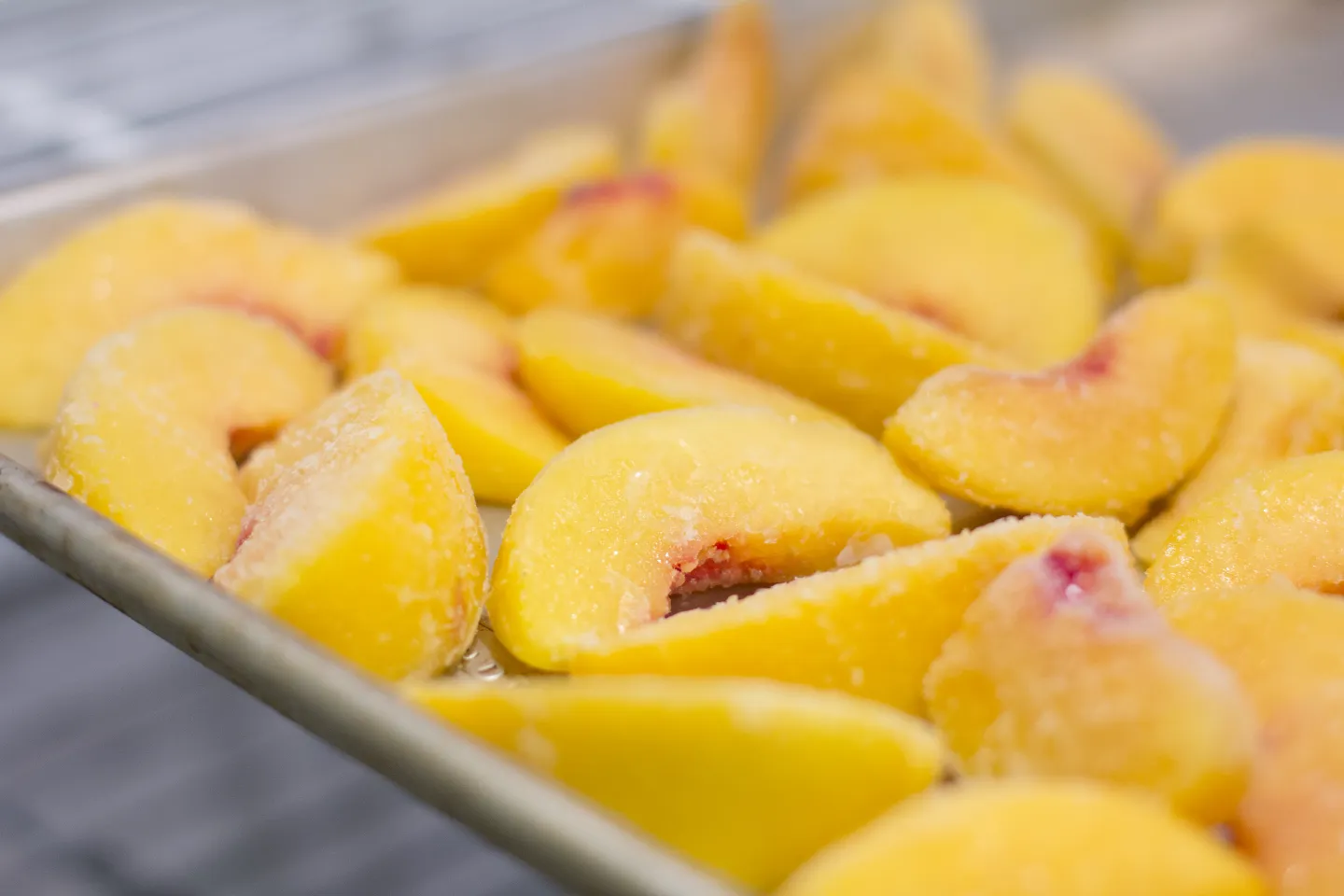 Frozen yellow peaches on a tray.