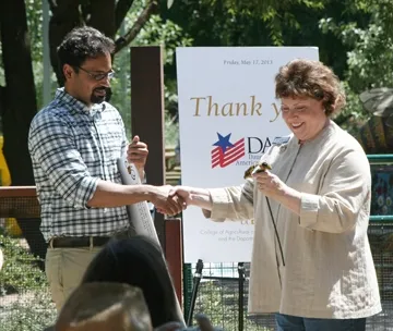 UC Davis bee scientist Brian Johnson with state regent DDebbie Jamison. She is holding a mosaic ceramic bee gift, the work of artist Donna Billick of Davis. (Photo by Chris Akins)