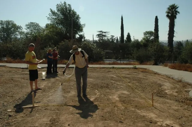 A participant in the training is spraying within an area marked while someone records the time in seconds needed to spray the area
