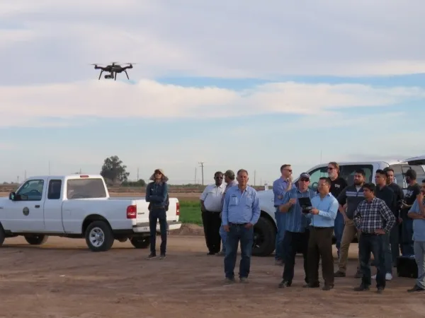 Participants at an IGIS drone workshop at Desert Research and Extension Center gain practice flying a drone.