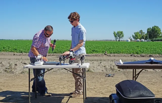 Justin Metz, left, and Emery Silberton are part of the technology integration team at Bowles Farm. They flew a small drone to demonstrate their crop monitoring practices.