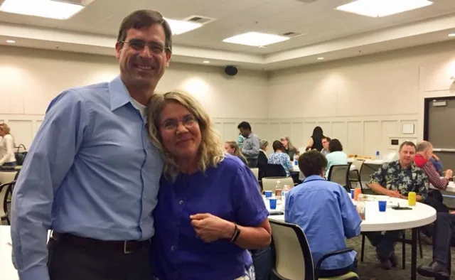 David Lewis, chair of the Communications Advisory Board, congratulates Ann Senuta on her retirement.