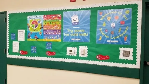 Healthy Posters and decals are placed along the wall where students typically wait in line for lunch.