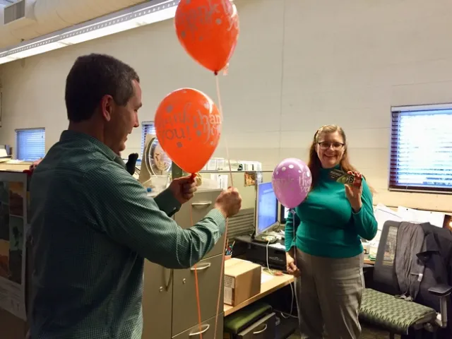 Scott Brayton of Development Services delivers a balloon to Belinda Messenger-Sikes of IPM.