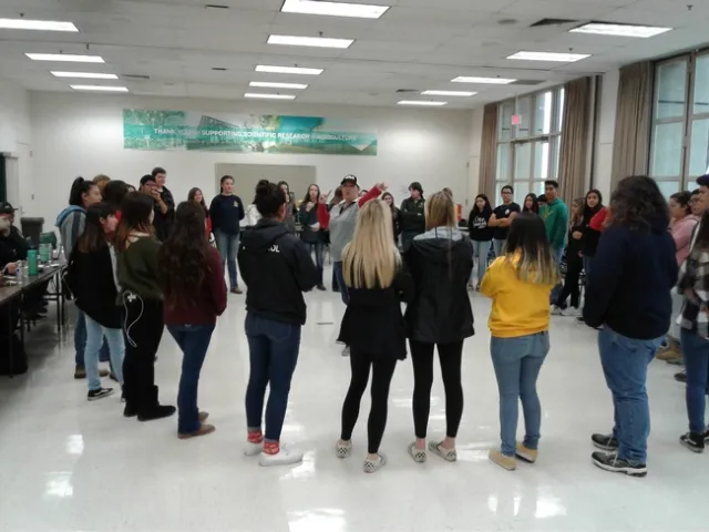 The students circle in a team-building exercise.