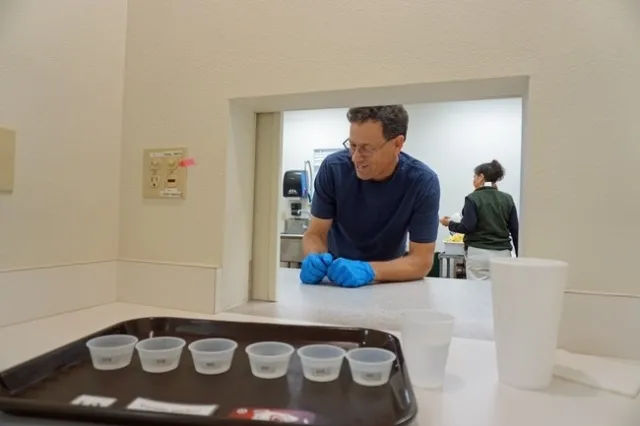 El técnico de USDA, Paul Neipp, presenta una bandeja para las pruebas de agua con limón en una de las estaciones del laboratorio sensorial.