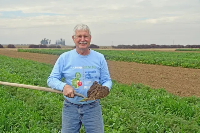 UCCE cropping systems advisor Jeff Mitchell with a shovelful of healthy soil at the UC West Side Research and Extension Center.