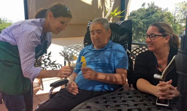 A workshop participant was invited to explore all senses of gardening, with flowers, seed packets and garden tools. (Photo: Debbie Handal)