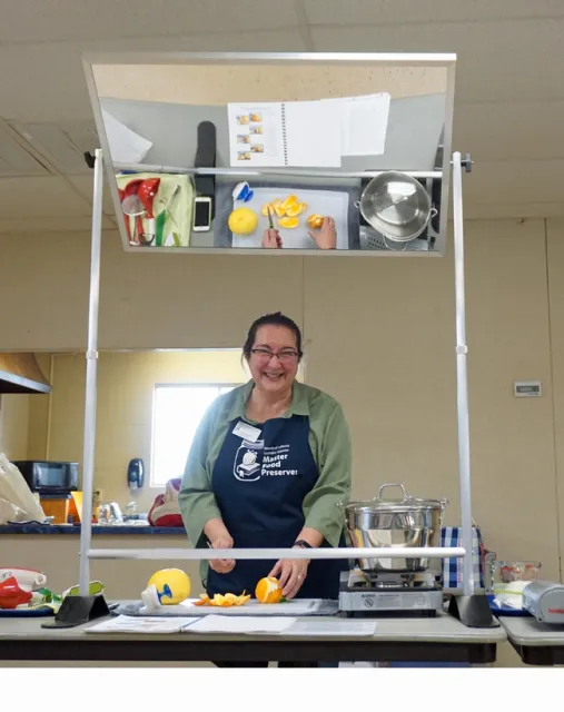 Sue Mosbacher prepares fruit for canning.