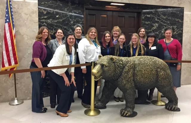 The UC ANR delegation, including Glenda Humiston and Wendy Powers, poses with the California bear statue outside the governor's office.