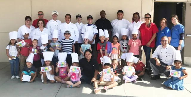 Community college student teachers with Preschoolers who received a certificate and chef's hat