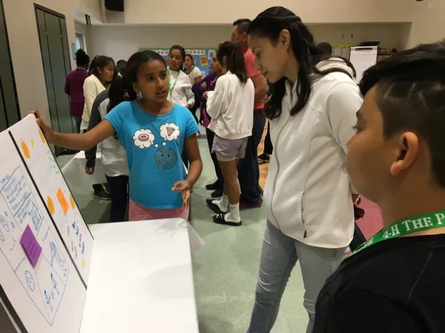 YOuth pointing to a poster she made