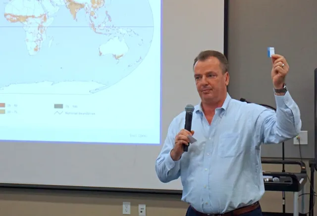 UC Cooperative Extension specialist Frank Mitloehner holds a business-card sized piece of paper which represents all ag land on the planet if the entire planet were represented by a letter-sized paper. See his demonstration and explanation in the video below.