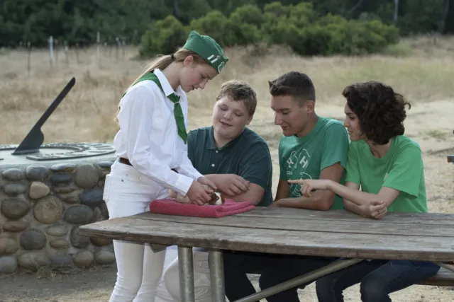 Girl showing cavy to three teens
