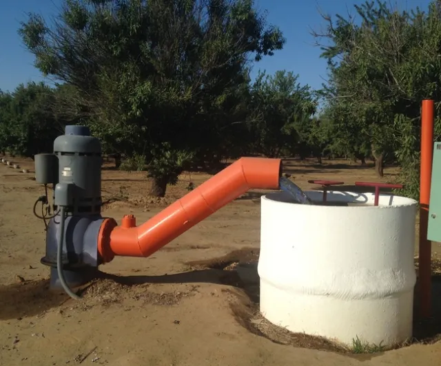 Groundwater is drawn by a pump to irrigate almonds in Fresno County.