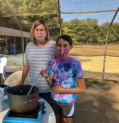 woman and child cooking with masks