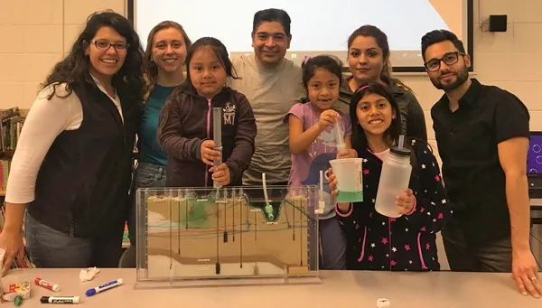 Dr. Sam Sandoval (center) shows afterschool program youth a groundwater model. Photo by Jose Huerta.