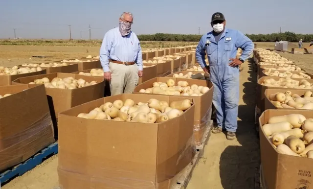 West Side farmer John Diener, left, and UC West Side Research and Extension Center superintendent of agriculture Rafael (Merf) Solario, post with the 70,000 pounds of butternut squash grown in a research plot and donated to the Central California Food Bank.