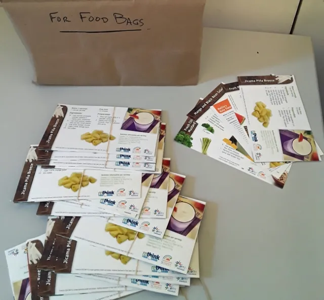 An array of recipe cards including mango and black bean salsa and jicama piña breeze are shown on a table.