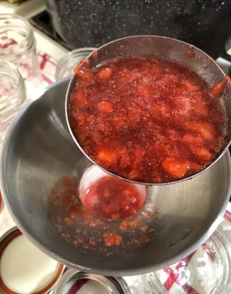 Hot jam ladled into jars