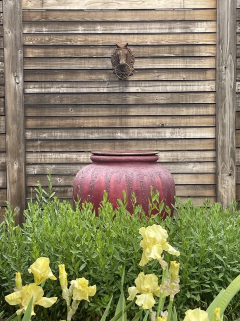 Red urn accents in the garden palette