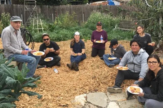 Gretchen Heimlich (3rd from left) and volunteers enjoying a delicious feast of food grown in the Strub Avenue Community Garden.