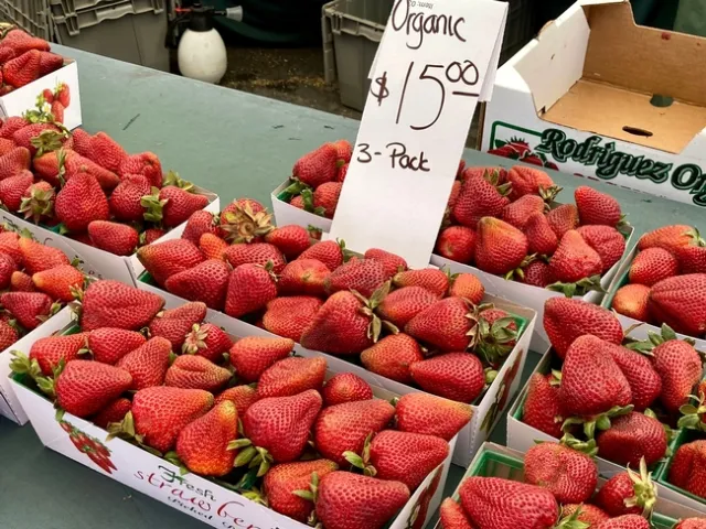 Organic red strawberries in baskets at farmers market