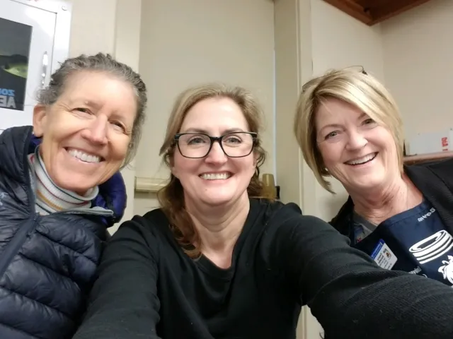 Three UC Master Food Preserver volunteers smiling at a workshop