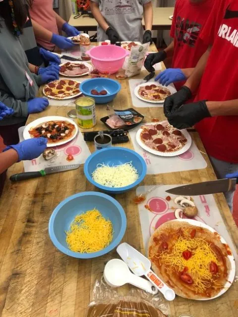 Teens Love Cooking students assembling “Myplate” pizzas