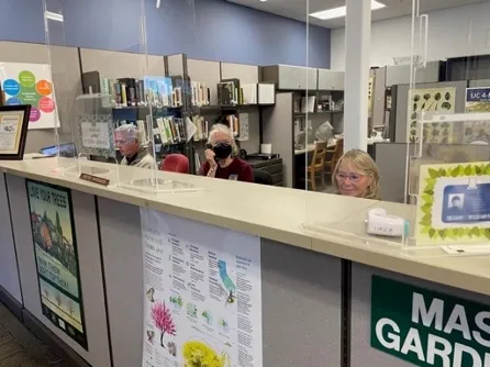 Three UC Master Gardeners behind a help desk