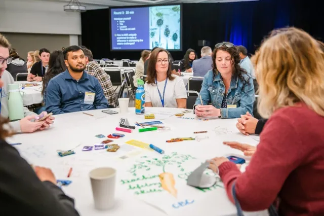 People sit around a round table talking.