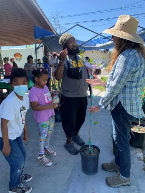 master gardeners explaining tree attributes to a person who will be planting the tree at home.