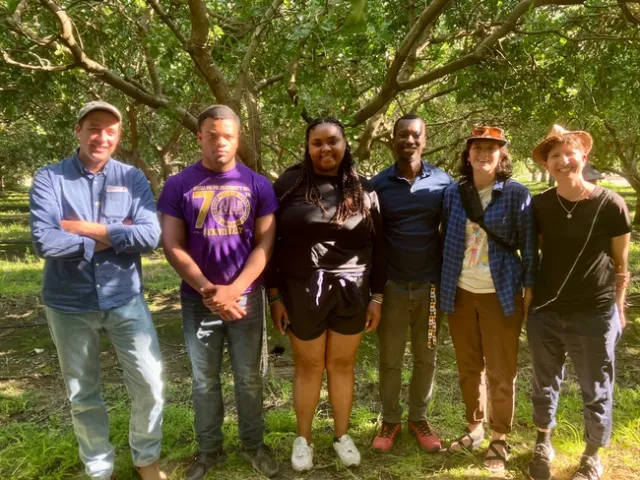 The group stands among trees