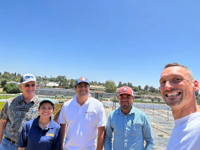 A group of adults smiling at the camera while standing in a nursery.