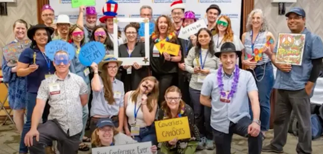 IPM team mugs for the camera wearing funny hats and holding props.