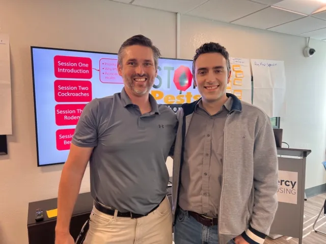 Two men, smiling at the camera, standing shoulder to shoulder.