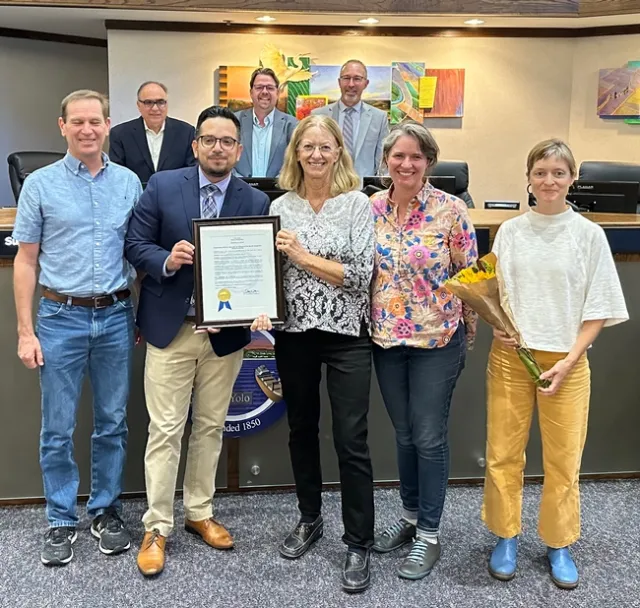 Rachael Long and Supervisor Angel Barajas hold up a plaque.